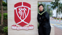 Mr IP Chun Ho Michael in graduation gown and the College entrance sign